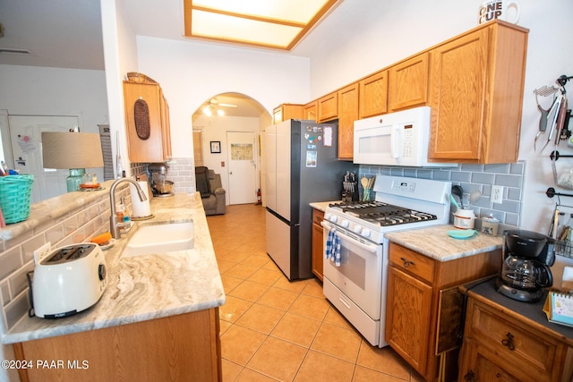 kitchen with ceiling fan, sink, white appliances, decorative backsplash, and light tile patterned floors