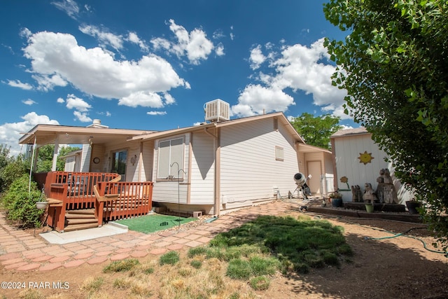 rear view of house with central AC unit and a deck