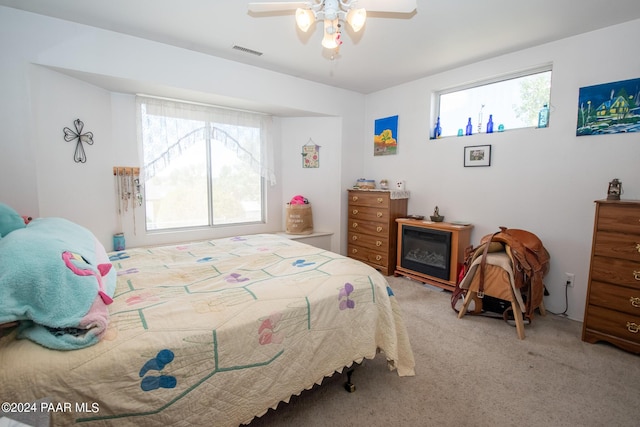 carpeted bedroom with multiple windows and ceiling fan