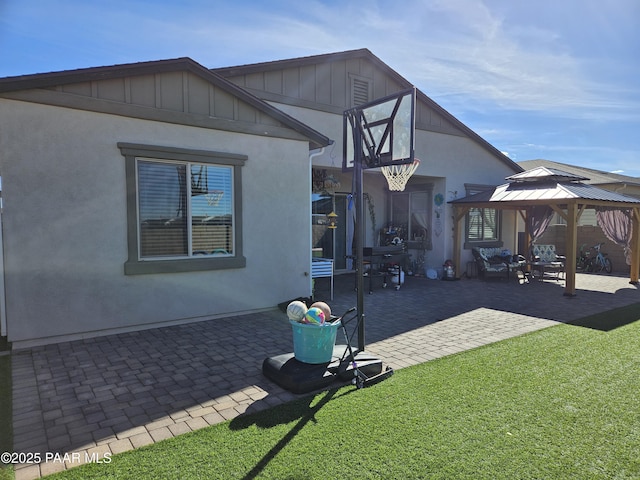 rear view of house featuring a gazebo, a patio, and a lawn