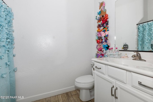 bathroom featuring wood-type flooring, vanity, and toilet