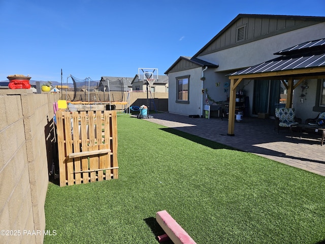 view of yard with a gazebo, a trampoline, and a patio area