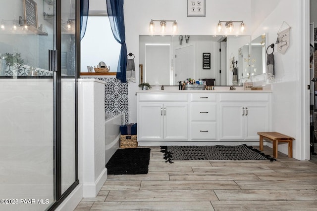 bathroom featuring vanity and independent shower and bath