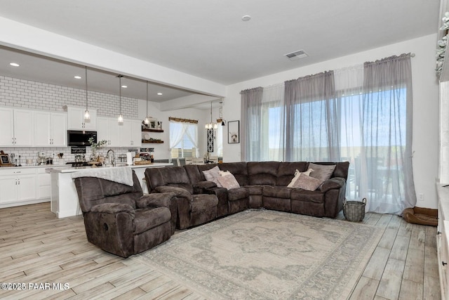 living room with an inviting chandelier and light hardwood / wood-style floors