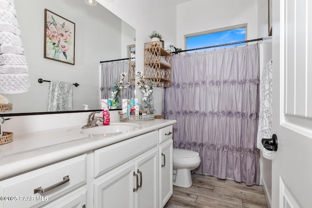 full bathroom with hardwood / wood-style flooring, vanity, shower / bath combo, and toilet