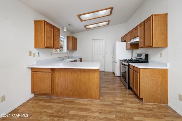15015 E White Dr, Dewey-Humboldt, AZ 86327 - kitchen featuring stainless steel gas range, under cabinet range hood, vaulted ceiling, a sink, and freestanding refrigerator