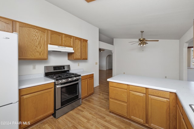 15015 E White Dr, Dewey-Humboldt, AZ 86327 - kitchen featuring gas range, freestanding refrigerator, under cabinet range hood, arched walkways, and ceiling fan