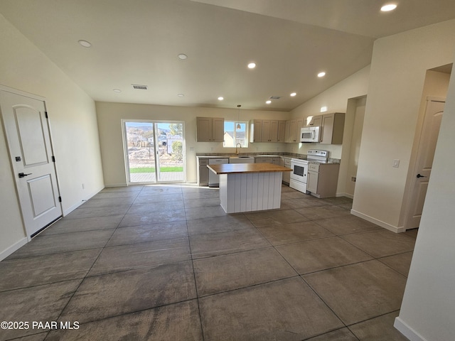 kitchen with pendant lighting, a center island, lofted ceiling, white appliances, and sink