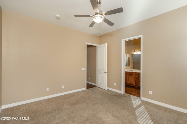 unfurnished bedroom with ceiling fan, light colored carpet, and ensuite bathroom