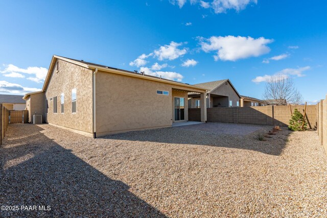 rear view of house with central AC and a patio