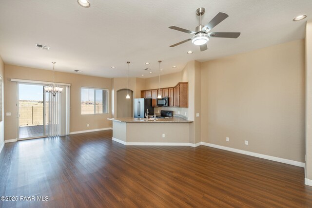 unfurnished living room with ceiling fan with notable chandelier and dark hardwood / wood-style flooring