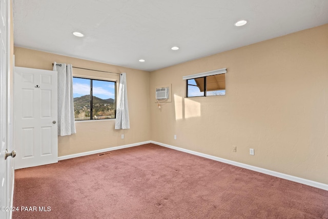 carpeted empty room featuring a wall mounted AC