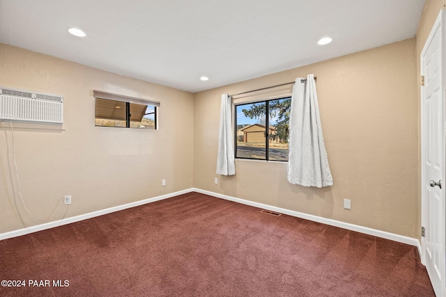 empty room featuring carpet and a wall mounted air conditioner