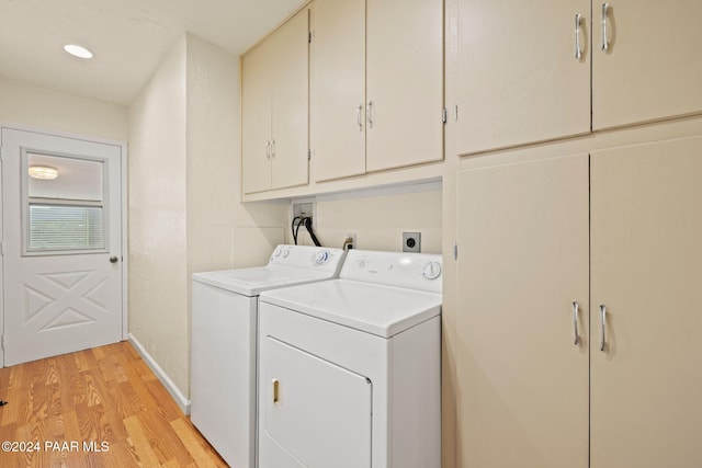 washroom featuring washer and clothes dryer, cabinets, and light hardwood / wood-style flooring