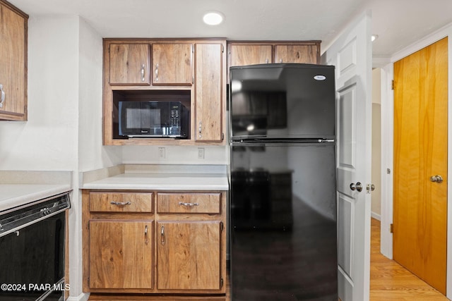 kitchen with light hardwood / wood-style floors and black appliances