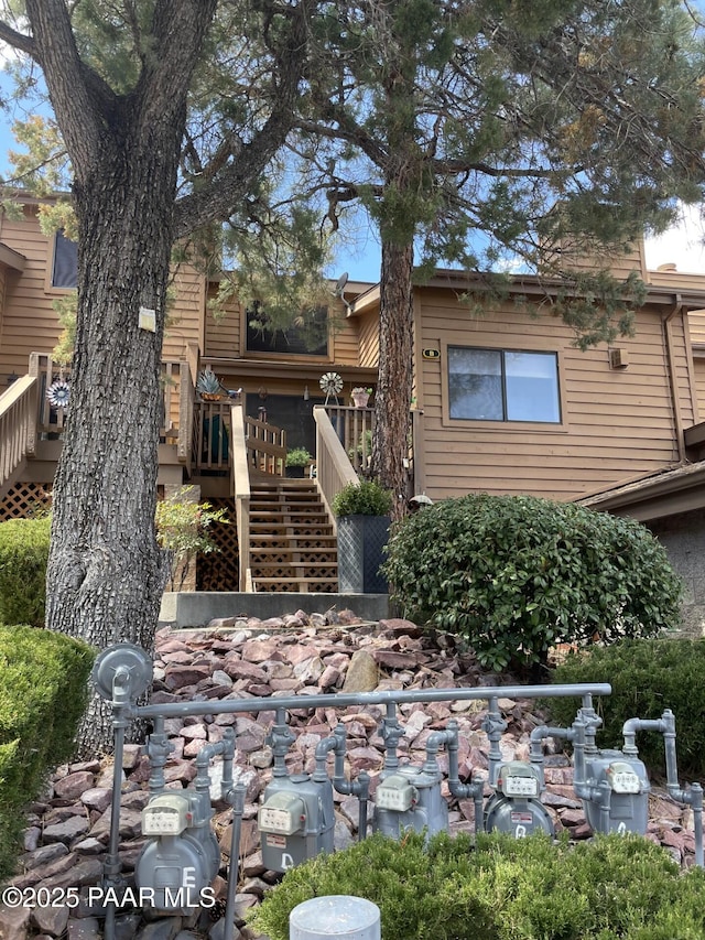 rear view of house featuring stairway and a deck