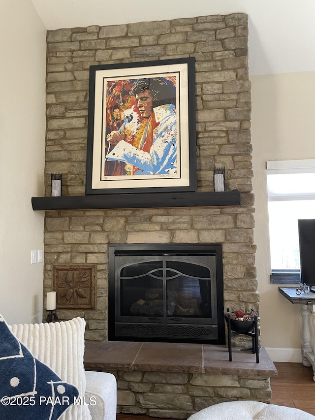 room details featuring a fireplace, wood finished floors, and baseboards