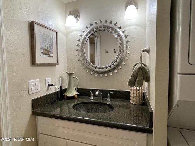 bathroom featuring a textured wall and vanity