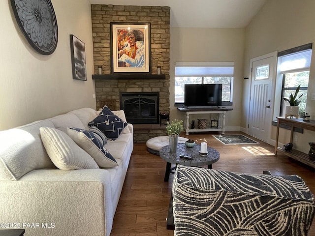 living area with a stone fireplace and wood-type flooring
