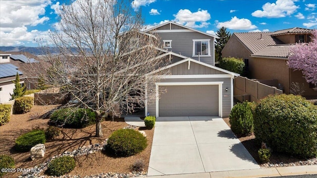 craftsman-style home with concrete driveway, board and batten siding, and fence