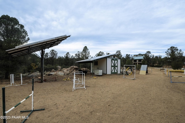 exterior space with a storage shed and an outbuilding