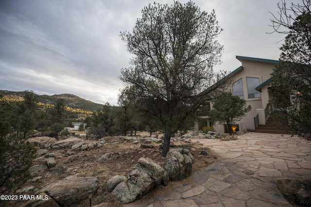 exterior space with a patio, stucco siding, and a mountain view