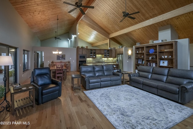 living room featuring beam ceiling, light wood-style flooring, high vaulted ceiling, and ceiling fan with notable chandelier