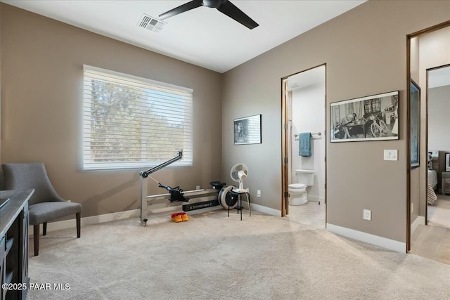 exercise area featuring light colored carpet and ceiling fan