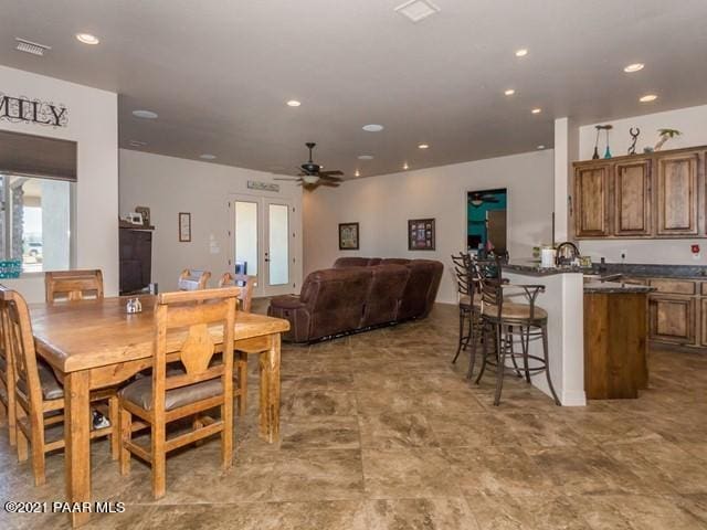 dining space with ceiling fan and french doors