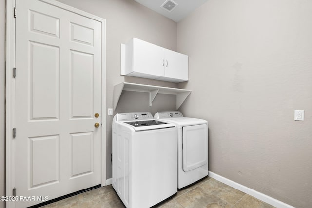 washroom featuring baseboards, visible vents, cabinet space, and washing machine and clothes dryer