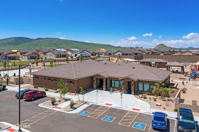 exterior space with uncovered parking, a residential view, and a mountain view