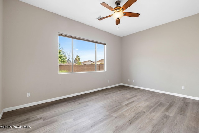 unfurnished room with ceiling fan, baseboards, and wood finished floors