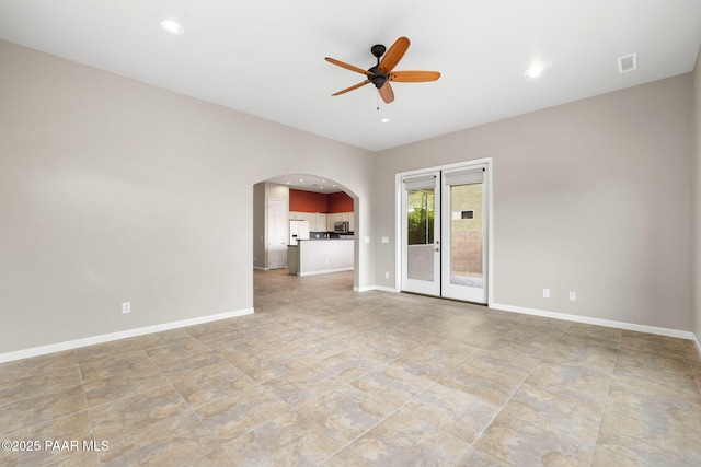 spare room with arched walkways, recessed lighting, a ceiling fan, and baseboards