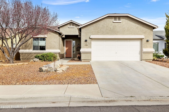 ranch-style house with concrete driveway, an attached garage, and stucco siding