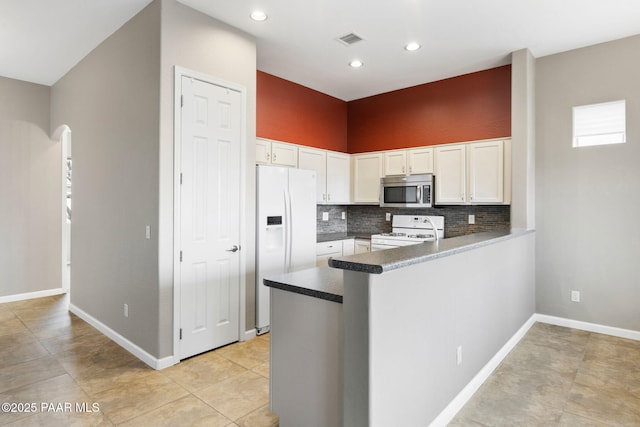 kitchen with white appliances, visible vents, a peninsula, and white cabinets