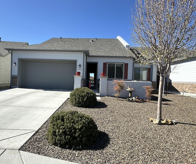 single story home featuring driveway, an attached garage, and a shingled roof