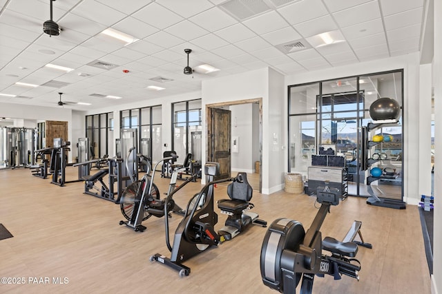 workout area featuring ceiling fan, visible vents, and wood finished floors