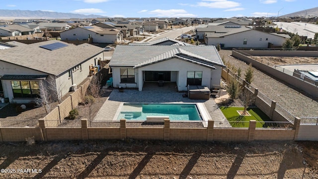 rear view of property featuring a residential view, a tile roof, and a fenced backyard