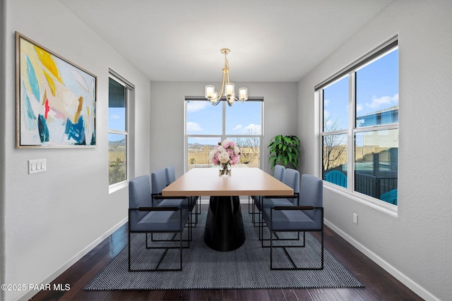 dining space featuring dark wood-style floors, plenty of natural light, baseboards, and a notable chandelier