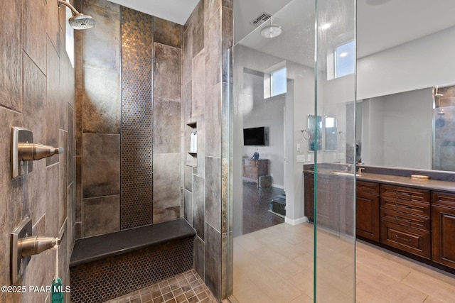 full bath featuring visible vents, vanity, and a walk in shower