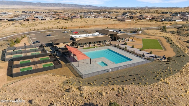 view of swimming pool with a residential view, fence, and a mountain view