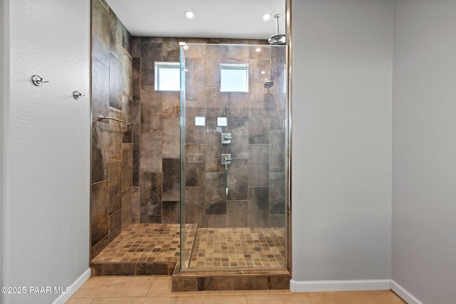 full bathroom featuring a stall shower and baseboards