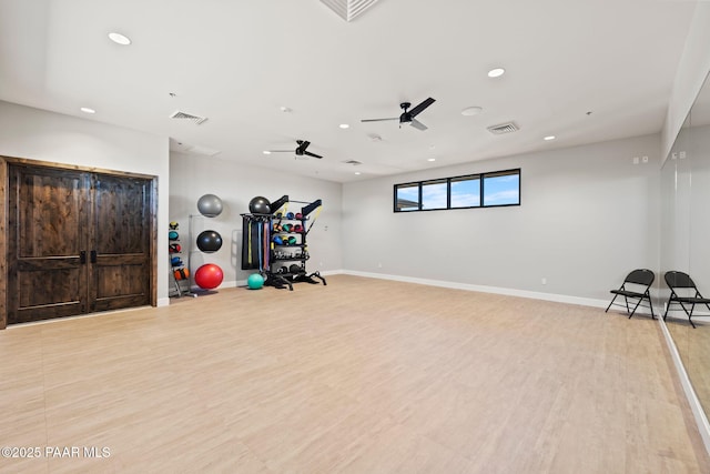 exercise room featuring light wood-type flooring, visible vents, and baseboards