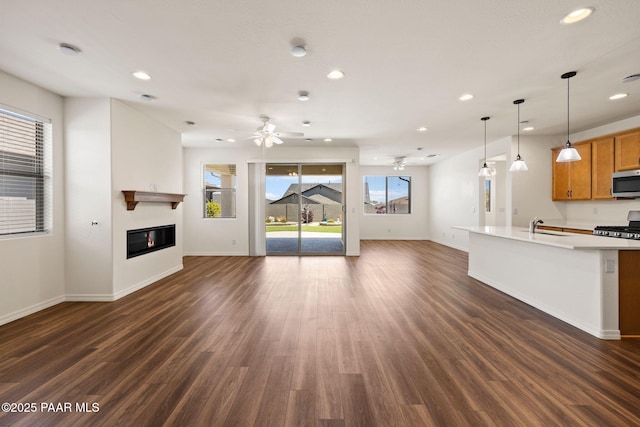 7912 Huckleberry Trl, Prescott Valley, AZ 86315 - unfurnished living room with a ceiling fan, recessed lighting, a sink, a glass covered fireplace, and dark wood-type flooring
