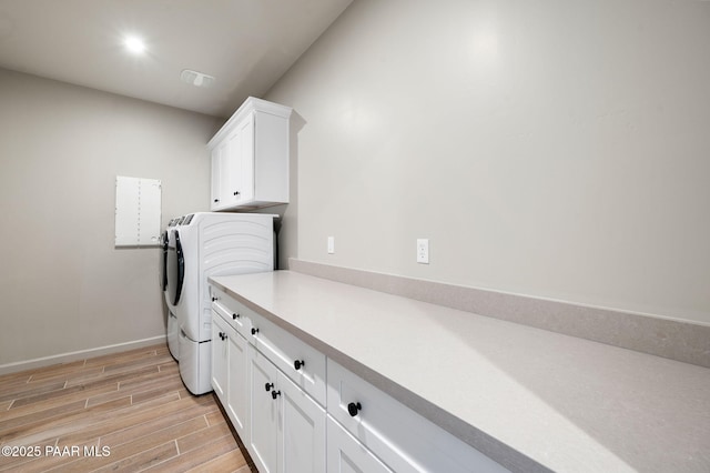 washroom with washer and clothes dryer, visible vents, cabinet space, wood tiled floor, and baseboards