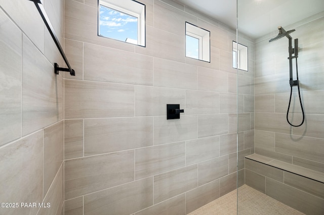 bathroom with plenty of natural light and a tile shower