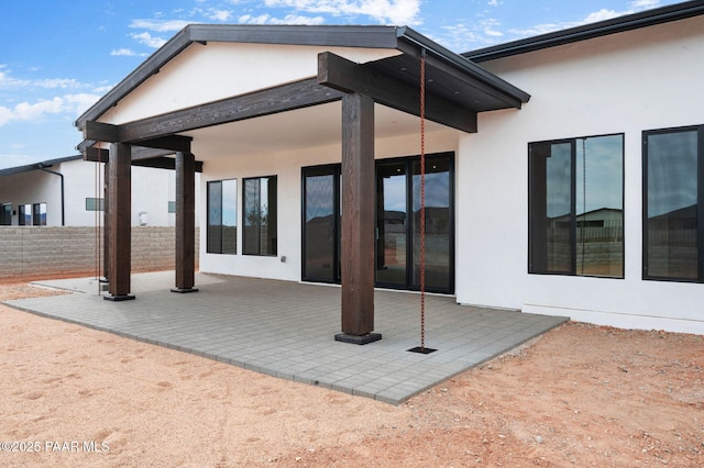 back of house with a patio, fence, and stucco siding