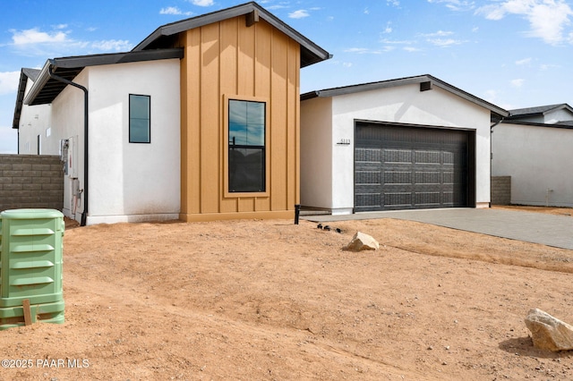 view of front facade featuring driveway, a garage, and stucco siding