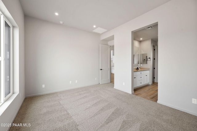 unfurnished bedroom featuring recessed lighting, visible vents, ensuite bathroom, light carpet, and baseboards