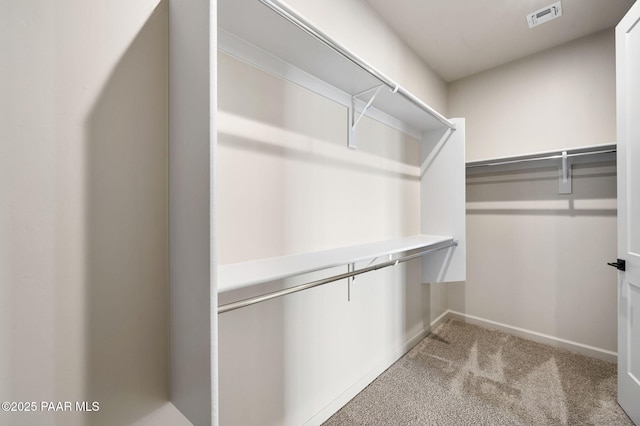 walk in closet featuring visible vents and light colored carpet